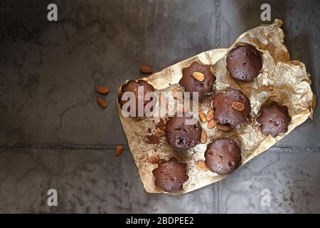 Dessert Schokoladenmuffins auf Pergamentpapier. Grauer Betonhintergrund Stockfoto