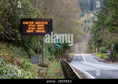 A82 in Tarbet von Loch Lomond, Schottland, Großbritannien. April 2020. Reiseängste am Osterwochenende - ein Schild auf der A82 vor dem Dorf Tarbet, in dem die Leute gebeten werden, zu Hause zu bleiben und nicht über die osterwochenende Gutschrift zu reisen: Kay Roxby/Alamy Live News Stockfoto