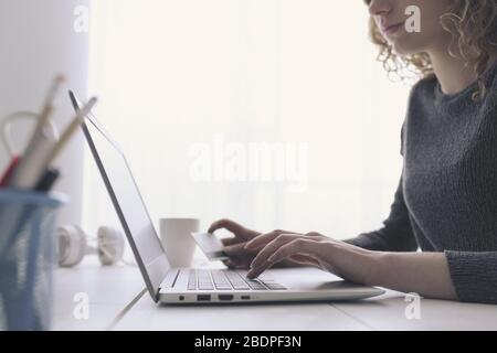 Frau, die mit ihrem Laptop und einer Kreditkarte online einkaufen kann, übergibt sich Nahaufnahme, E-Commerce und Online-Banking-Konzept Stockfoto