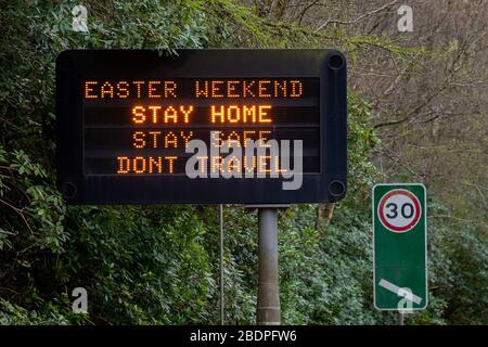 A82 in Tarbet von Loch Lomond, Schottland, Großbritannien. April 2020. Reiseängste am Osterwochenende - ein Schild auf der A82 vor dem Dorf Tarbet, in dem die Leute gebeten werden, zu Hause zu bleiben und nicht über die osterwochenende Gutschrift zu reisen: Kay Roxby/Alamy Live News Stockfoto