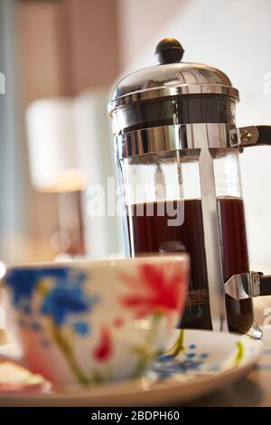 Tasse frischen Kaffee und eine französische Presse auf der Küchentheke Stockfoto