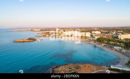 Vogelperspektive auf die berühmte Küste von Nissi, Ayia Napa, Famagusta, Zypern. Die Wahrzeichen der Touristenattraktion ist die Bucht bei Sonnenaufgang mit goldenem Stockfoto