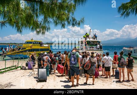 Horizontaler Blick auf Touristen, die Fähren in Gili Trawangan, Indonesien, einsteigen. Stockfoto