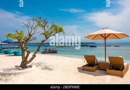 Horizontaler Blick auf die Sonnenliegen am Strand in Gili Trawangan, Indonesien. Stockfoto