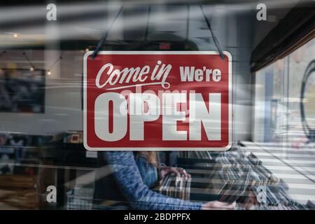 Ein Geschäftszeichen, das in einem Fenster eines Musik-/Plattengeschäfts „Come in We're Open“ steht. Stockfoto