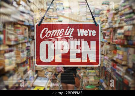 Ein Geschäftszeichen, das auf einem Buchladen-Fenster „Come in We're Open“ steht. Stockfoto