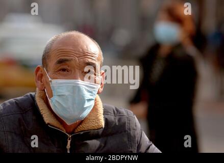 Peking, China. April 2020. Chinesen, die Schutzmasken tragen, fahren am Donnerstag, 9. April 2020 in Peking mit dem Fahrrad. Chinas Hauptstadt bremst die Rückkehr zu einem "normalen" Leben von drakonischen Sicherheitsmaßnahmen aufgrund des Covid-19-Ausbruchs, da die Regierung langsam einige Einschränkungen für Reisen und soziale Interaktionen aufhebt. Foto von Stephen Shaver/UPI Credit: UPI/Alamy Live News Stockfoto