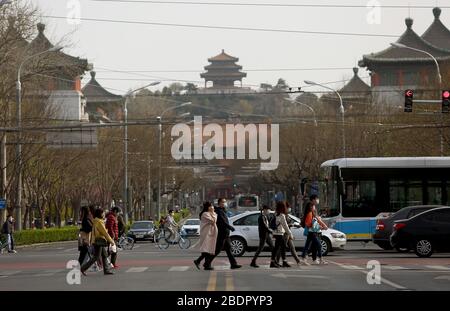 Peking, China. April 2020. Chinesen, die Schutzmasken tragen, gehen am Donnerstag, den 9. April 2020 durch eine Kreuzung im Zentrum Pekings. Chinas Hauptstadt bremst die Rückkehr zu einem "normalen" Leben von drakonischen Sicherheitsmaßnahmen aufgrund des Covid-19-Ausbruchs, da die Regierung langsam einige Einschränkungen für Reisen und soziale Interaktionen aufhebt. Foto von Stephen Shaver/UPI Credit: UPI/Alamy Live News Stockfoto