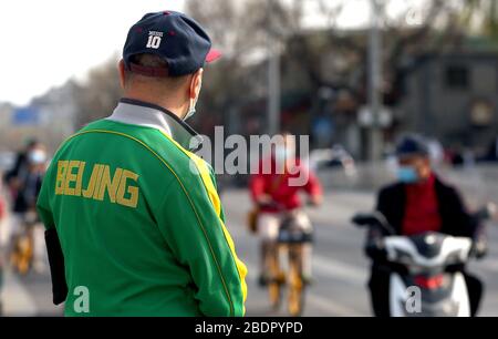 Peking, China. April 2020. Chinesen, die Schutzmasken tragen, fahren am Donnerstag, 9. April 2020 in Peking mit dem Fahrrad. Chinas Hauptstadt bremst die Rückkehr zu einem "normalen" Leben von drakonischen Sicherheitsmaßnahmen aufgrund des Covid-19-Ausbruchs, da die Regierung langsam einige Einschränkungen für Reisen und soziale Interaktionen aufhebt. Foto von Stephen Shaver/UPI Credit: UPI/Alamy Live News Stockfoto