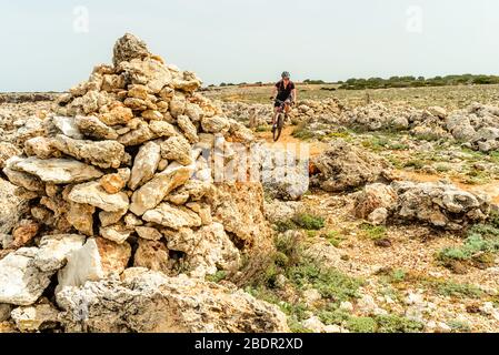 Mountainbiker auf dem Küstenpfad "Cami de Cavalls" in der Nähe von Ciutadella auf Menorca auf den Balearen, Spanien Stockfoto