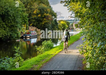 Frau, die auf dem Weg zum Leeds und Liverpool Canal in Rishton, Lancashire, fährt Stockfoto