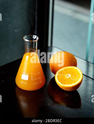 Orangensaft im Glas und frische Orange daneben Stockfoto