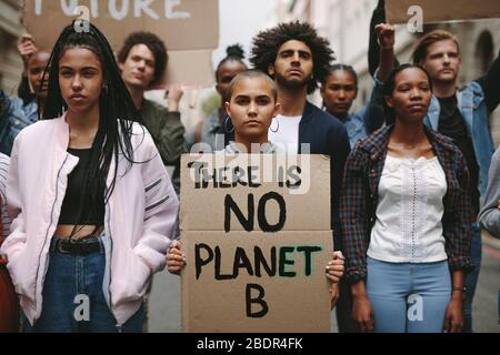 Gruppe von Aktivisten mit Bannern, die gegen Umweltverschmutzung und Erderwärmung protestieren. Männliche und weibliche Aufstände, die einen stillen Protest zur Rettung des Planeten Erde tun. Stockfoto