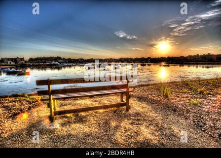 Dorf Plouhmanac’h, Frankreich. Künstlerische Sicht auf den Sonnenaufgang auf einer leeren Sitzbank am Boulevard des Traouiero in Ploumanac'h. Stockfoto
