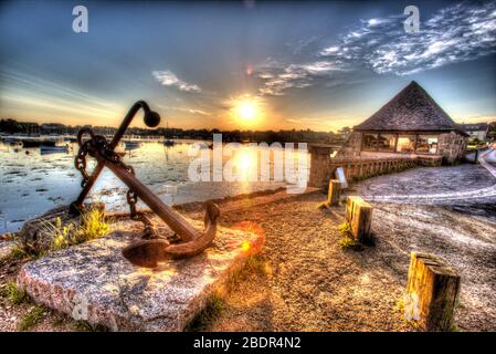 Dorf Plouhmanac’h, Frankreich. Künstlerische Sonnenaufgang Blick auf ein Anker-Denkmal am Port de Ploumanac'h, mit der Tide Mill aus dem 18. Jahrhundert im Hintergrund Stockfoto