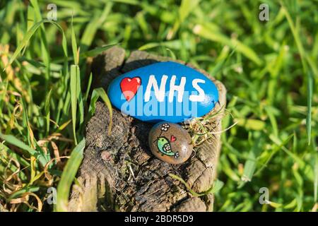 Bemalter Stein mit einem Herzen und NHS bemalt. Gefunden durch Fußweg in Perry Green, Much Hadham, Hertfordshire. Großbritannien, während der Coronavirus Covid 19-Krise Stockfoto