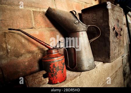 Oldtimer Öldosen und Shell Motor Spirit Benzinkanister in der Garage. Stockfoto