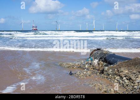 Abfallabflussrohr am Coatham Strand mit Jack Up Rig, MPI Adventure, Installation von Offshore-Windenergieanlagen in Redcar, Nordostengland, Großbritannien Stockfoto