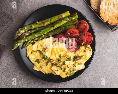 Rührei mit gebratenem Tomatenspargelfrühstück, gesundes Essen Stockfoto