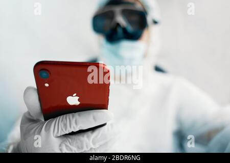 Bischkek, Kirgisistan - Marth 14 2020: Bio hazrd man mit iphone. Männlich beobachten in roten iphone. Stockfoto