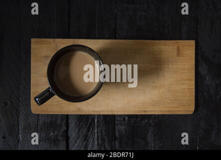 Kaffee mit Milch auf Holztisch von oben gesehen, auf schwarzem Holztisch mit grauem Hintergrund. Stockfoto