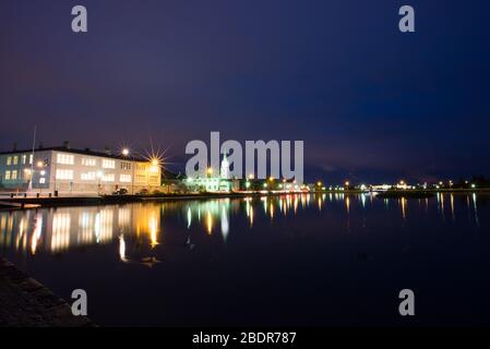 Tjörnin See in Reykjavik bei Nacht mit der Kirche Fríkirkjan í Reykjavík, Reykjavik, Island Stockfoto