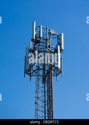 Spitze eines Mobilfunkmasts vor einem schlichten blauen Himmel Hintergrund in Perry Green, Much Hadham, Hertfordshire. GROSSBRITANNIEN Stockfoto