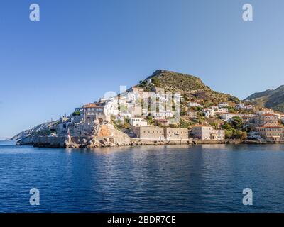 Insel Hydra Haupthafen, vom Meer aus gesehen, mit traditionellen Häusern und Hügeln, in Argolid Meer, Griechenland. Stockfoto