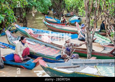 Einheimische Frauen laden Touristen zu einer Bootsfahrt durch die Sümpfe und Dschungelflüsse am Rande des Tonle SAP Sees, Kampong Phluk, Kambodscha ein. Stockfoto