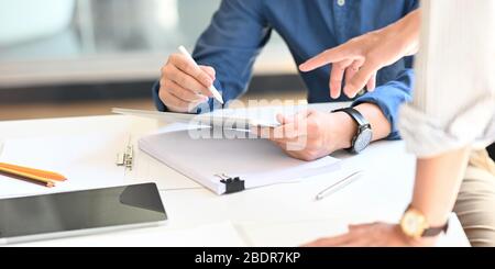 Zugeschnittenes Bild von den Händen des Architekten Mann hält einen Stift und Computer-Tablet für die Zeichnung ein Projektkonzept mit Kollegen an der modernen Arbeits des Stockfoto