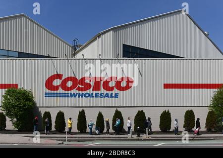 Ein Blick auf Leute, die außerhalb von Costco in Queens, New York Schlange stehen, nachdem Supermärkte eine Reihe neuer Maßnahmen eingeführt haben, um Läden offen zu halten Stockfoto