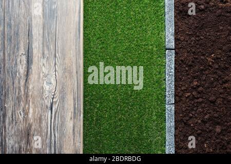 Holztisch, fruchtbarer Humusboden, üppiges Gras und Steinkanten, Garten- und Landschaftskonzept Stockfoto