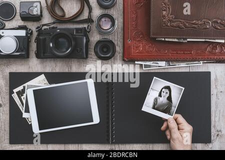 Fotoausrüstung, Kameras, digitales Tablet und Fotoalbum, ein Fotograf hält ein sofortiges Bild, flaches Lay Stockfoto