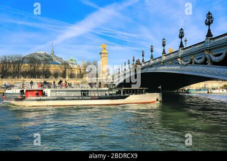 Paris, Frankreich - 20. Dezember 2018: Touristen Boot unter der berühmten Brücke Pont Alexandre III über die seine an sonnigen Tagen. Stockfoto