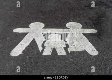 Symbol eines Eltern- und Kinderparkplatzes, der in weißer Farbe auf Asphalt auf einem Parkplatz gezeichnet ist Stockfoto