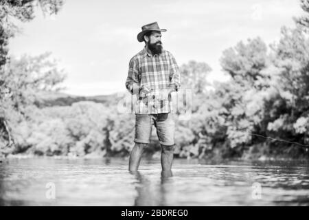 Ruhige und friedliche Stimmung. Fischer allein im Wasser des Flusses. Mann bärtigen Fischer. Fischer Angelausrüstung. Eine Art der Meditation. Fische in der Regel in freier Wildbahn gefangen. Trout Farm. Hobby Sport. Stockfoto