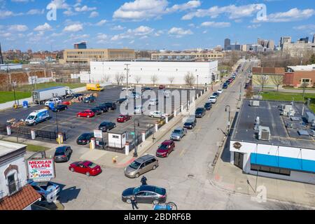 Detroit, Michigan, USA. April 2020. Während der Coronavirus-Krise verteilt die Gleaners Community Food Bank kostenlose Lebensmittel an bedürftige Bewohner im Südwesten Detroits. Eine lange Linie von Autos erstreckt sich in Richtung Innenstadt. Kredit: Jim West/Alamy Live News Stockfoto