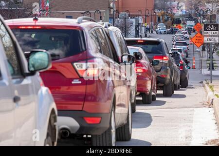 Detroit, Michigan, USA. April 2020. Während der Coronavirus-Krise verteilt die Gleaners Community Food Bank kostenlose Lebensmittel an bedürftige Bewohner im Südwesten Detroits. Eine lange Autofahrstrecke wartet auf den Zugang zum Verteilstandort. Kredit: Jim West/Alamy Live News Stockfoto