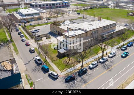 Detroit, Michigan, USA. April 2020. Während der Coronavirus-Krise verteilt die Gleaners Community Food Bank kostenlose Lebensmittel an bedürftige Bewohner im Südwesten Detroits. Eine Reihe wartender Autos umschlingt den Block. Kredit: Jim West/Alamy Live News Stockfoto