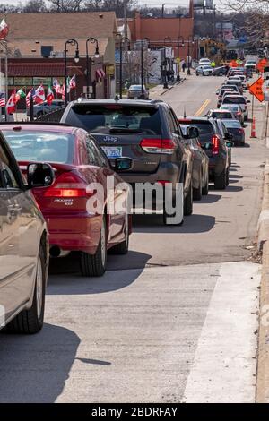 Detroit, Michigan, USA. April 2020. Während der Coronavirus-Krise verteilt die Gleaners Community Food Bank kostenlose Lebensmittel an bedürftige Bewohner im Südwesten Detroits. Eine lange Autofahrstrecke wartet auf den Zugang zum Verteilstandort. Kredit: Jim West/Alamy Live News Stockfoto