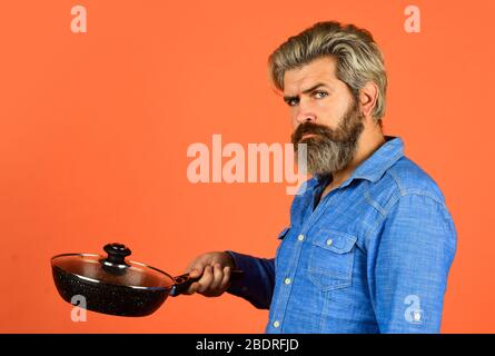 Wer kümmert sich um Ernährung. Kulinarisch und Küche. Küchenutensilien. Gesundes Essen Kochen. Kochen schmackhafte Gericht. Bärtige Mann halten Bratpfanne. Kochen im Topf. Für die Zubereitung von Speisen. Bärtiger Mann, der in der Küche kocht. Stockfoto