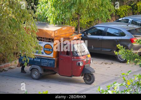 Auto Rikscha mit Indane Kochgase aus indischem Öl an den Seiten in der Mitte einiger Bäume markiert Stockfoto