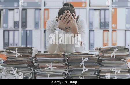 Frustriert Sie Büroangestellter lehnte sich auf Haufen Papierkram, sie ist mit Arbeit überlastet und gestresst Stockfoto