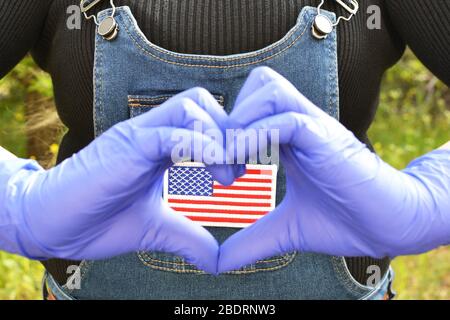 Konzentrieren Sie sich auf US-Flagge Batch auf eine Jeans Pullover mit Frauen Hände in Handschuhen machen Liebe Geste Stockfoto