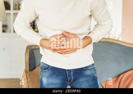 Junger Mann, der an Bauchschmerzen leidet Stockfoto