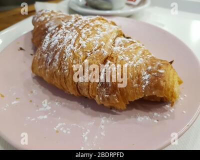 Französischer Croissant mit Puderzucker bedeckt Stockfoto