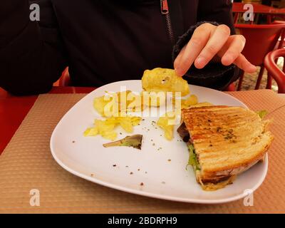 Frau, die Toast und Kartoffelchips isst Stockfoto