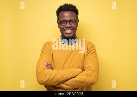 Lächelnder junger afroamerikanischer Mann mit Brille lächelnd selbstbewusst Stockfoto