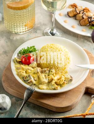 Cremiges Hühnchen und Pilzsaute mit Reis und Gemüse serviert Stockfoto
