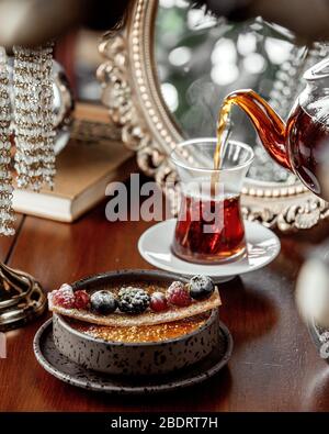 Dessertschale mit schwarzem Tee aus Teekanne gegossen serviert Stockfoto